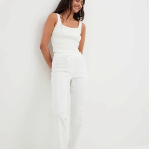 Stilrena vita kostymbyxor till salu! - Säljer klassiska vita kostymbyxor från Nakd i utmärkt skick. Endast testade.Perfekta för både festliga tillfällen och en mer vardagslook.Byxorna har en snygg passform och är stretchiga. Säljer för att de är lite långa och stora på mig som är 160 cm. 