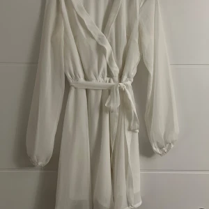 Vit klänning - Vit klänning i nyskick. Passar perfekt till studenten! Knytning runt midjan.