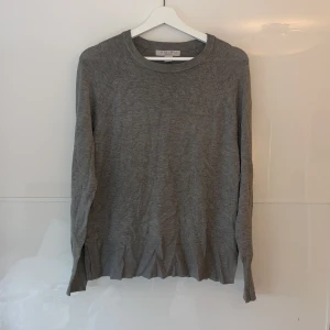 Grå tröja från New Yorker - Säljer en stilren grå tröja från New Yorker i storlek M. Tröjan är långärmad och har en enkel design, men en slits på båda sidorna vid midjan, som passar perfekt till vardags. Materialet känns mjukt och bekvämt, perfekt för höst och vår. Perfekt basplagg att ha i garderoben!