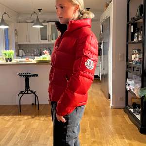 Vintage lite äldre moncler jacka i röd som har tappat självaste draget på dragkedjan som jag snabbt ersatt men en annan som går att ändra! Eftersom att den är köppt vintage så finns ingen QR scann men den ska vara äkta! Små defekter finns skriv pr