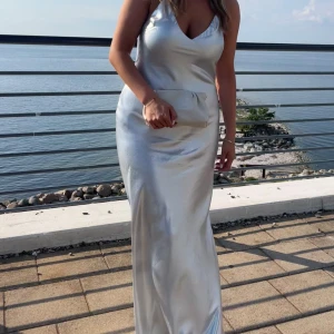 Silvrig balklänning mango  - Silvrig/skimrig. Säljer nu min balklänning från mango, nypris 1 500kr! Endast använd en gång, inga defekter förutom lite sminkfläckar på INSIDAN så inget som syns. Storleken är S och är 172 cm, lång till marken på mig och perfekt till klackar 🤩