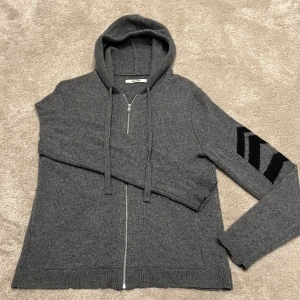 Zadig&Voltaire Kashmir Hoodie - Snygg grå Zip-Hoodie från Zadig & Voltaire. Den är 100% Kashmir och väldigt bekväm. Den är endast använd 3-5 gånger och är därför i perfekt skick utan defekter. Köptes från deras hemsida i vintras. Nypris: ~5500kr. Köparen står för frakten. Storlek S