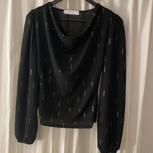 Långärmad tröja - Långärmad tröja lite urringad i halsen med guld detaljer.