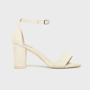 Beige sandaler med klack - Snygga och eleganta beige sandaler med en stabil klack och en smal rem runt ankeln. Perfekta för sommarens alla fester eller en stilren vardagslook. De har en öppen tå och är gjorda i ett mjukt material som ger en bekväm passform.