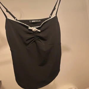 Svart satin linne med vit roset - Svart satin linne med vit roset och vita detaljer. Använt då och då, säljer då den kommer inte till användning längre. Köpt för 350kr. 