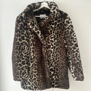 Leo kappa  - Kappa med leopardprint, mellan längd. Går över rumpan. Är i fint skick.  Storlek 38