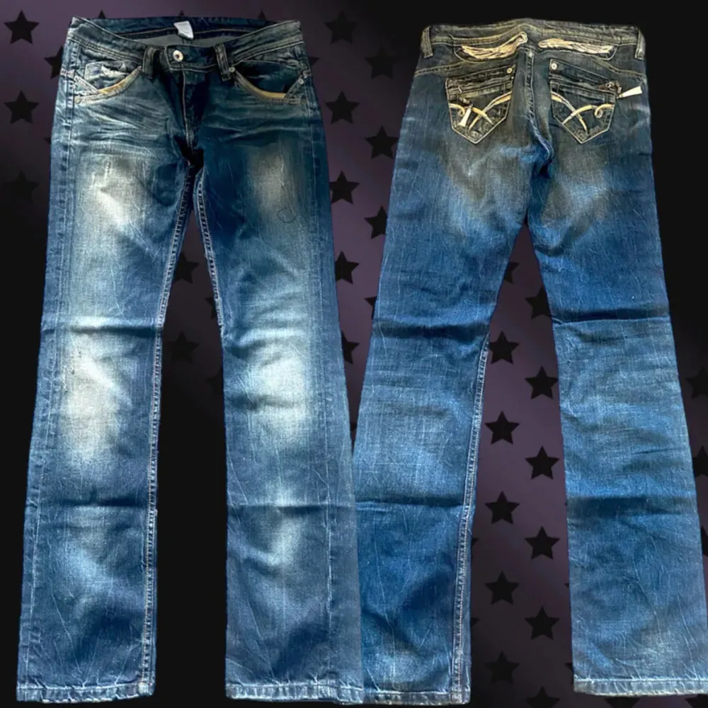 Säljer ett par snygga blå jeans med coola broderade detaljer på bakfickorna. Jeansen har en klassisk femficksdesign och en dekorativ tofs på ena fickan. Perfekta för en Y2K stil med en touch av unik design.. Jeans & Byxor.