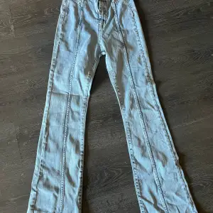 Säljer ett par ljusblå bootcut jeans i bra skick. De har en snygg söm längs benen som ger en cool detalj. Perfekta för både vardag och fest!