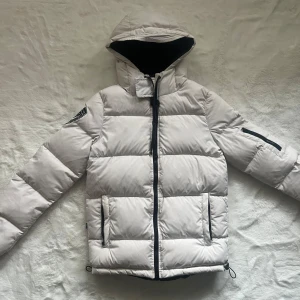 Vit Dbrand jacka - 200kr ENDAST IDAG! Vit jacka från Dbrand i storlek XS. Har ute jackan på flera ställen så först till kvarn! Dessa säljs tyvärr ej längre men  nyprs kring 1999-2199kr. Bra skick billigare vid snabb affär. Enda defekta på den är att reflexen på