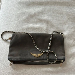  Zadig & Voltaire väska - Väska från Zadig, använd men fortfarande fin. Grå färg med gulddetaljer.