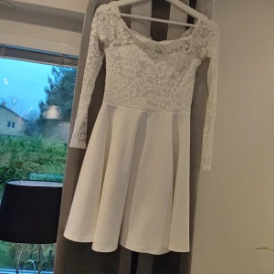 Vit spetsklänning från NLY One - Säljer en superfin vit klänning från NLY One i storlek S. Den har långa ärmar och är täckt med vacker spets upptill. Perfekt för sommarens fester eller studentfirandet! 💫