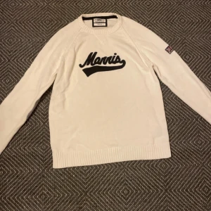 Vit tröja från Morris - Säljer en stilren vit tröja från Morris i storlek medium. Den har ett svart tryck på framsidan och gråa armbågslappar som ger en snygg touch. Perfekt för både vardag och lite finare tillfällen. Tröjan är i mycket bra skick och redo för en ny ägare!