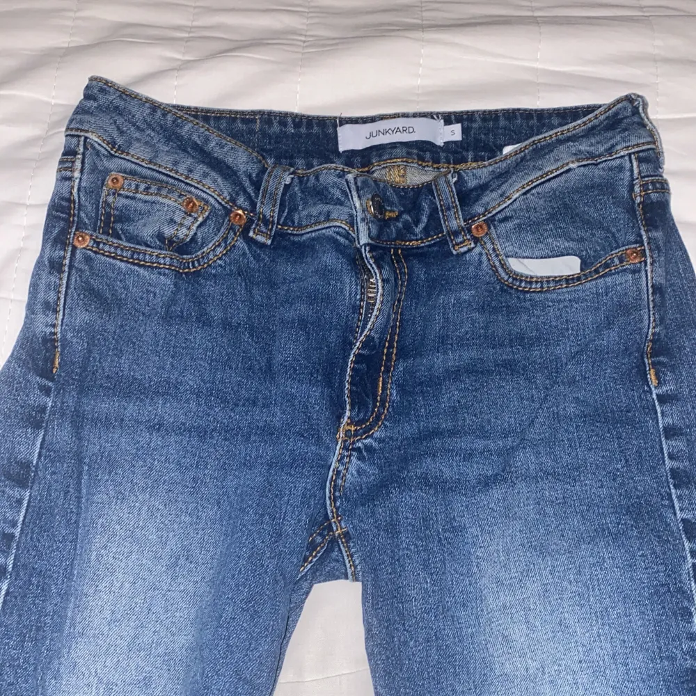 Säljer ett par snygga blå jeans från Junkyard i storlek S. De har en klassisk femficksdesign och är i bra skick. Perfekta för vardagsbruk med en bekväm passform. Passar till alla tillfällen!. Farkut & Housut.