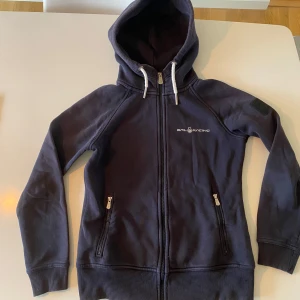 Zip hoodie Sail Racing dam M (mer som S) marinblå - Zip hoodie dam Medium men skulle aäga att den mer är som Small. Marinblå. Väl använd så lite urtvättad men inga hål el fläckar.