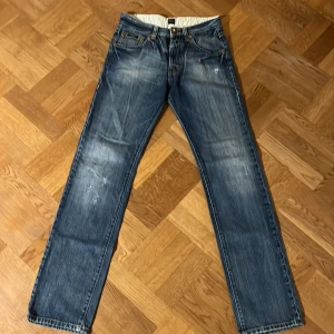 Blå jeans från Boss - Säljer ett par klassiska blå jeans från Boss i bra skick. De har en straight fit och är midwaist. Perfekta för vardagsbruk med snygga detaljer som knappar och dragkedja. Passar till både avslappnade och mer uppklädda tillfällen.
