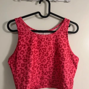 Rosa leopardmönstrad croppad topp - Säljer en supercool rosa linne med leopardmönster.Toppen är tight och framhäver figuren på ett snyggt sätt