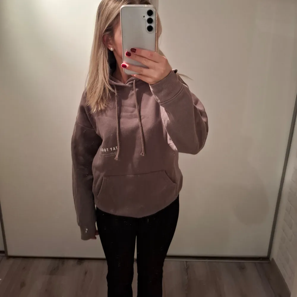 Mysig brun hoodie i mycket bra skick.Den har en klassisk känguruficka och justerbar huva med snören. Enkelt tryck på bröstet ger en stilren look.. Hoodies.