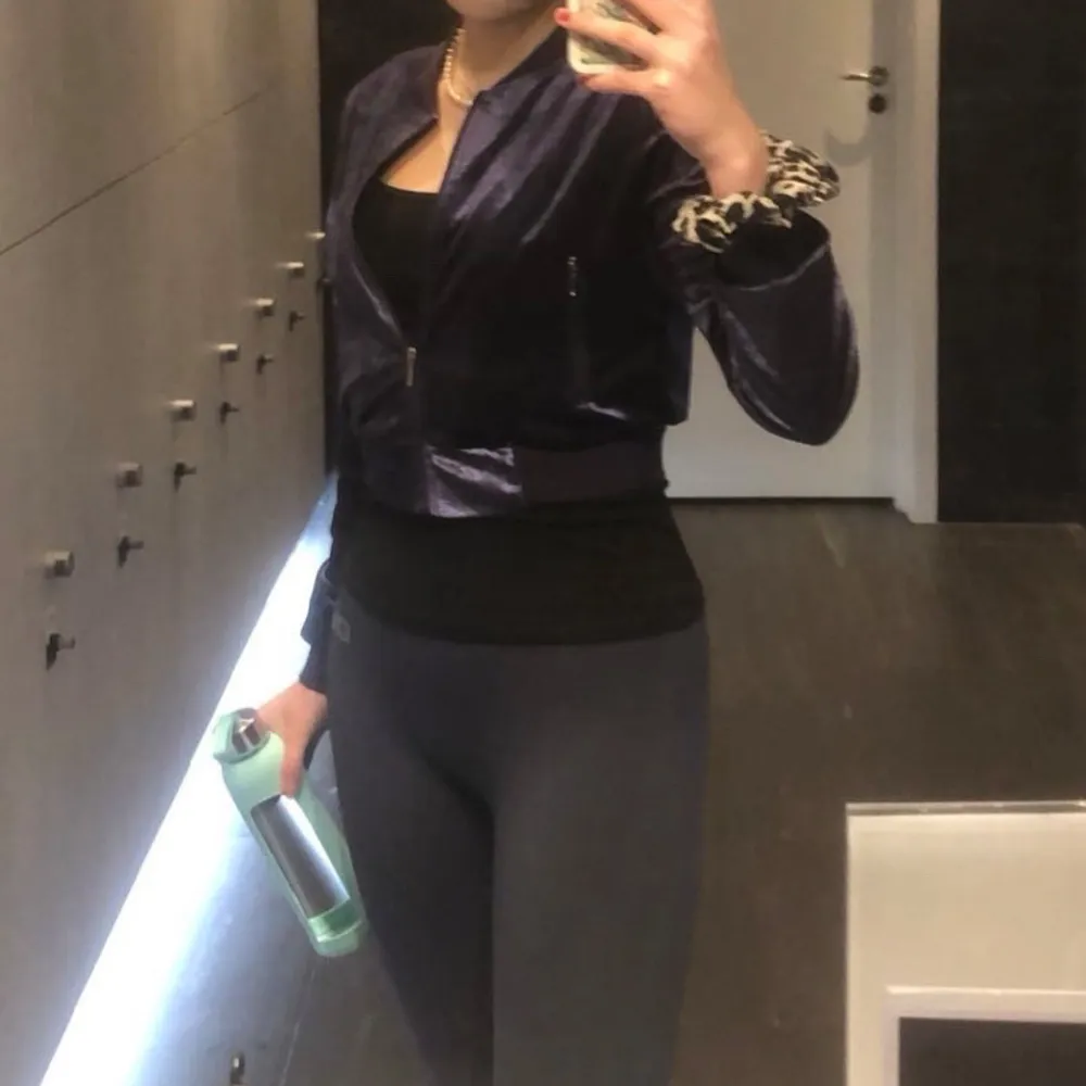 Superfin mörklila velourjacka från Gina Tricot. Den är croppad med dragkedja och har långa ärmar. Jackan har två fickor med dragkedjor framtill. . Takit.