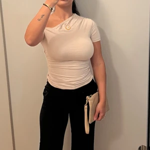 Beige offshoulder topp - Säljer en snygg beige offshoulder topp som är perfekt för både vardag och fest. Den är tight och har korta ärmar, vilket ger en stilren look. Toppen är i ett mjukt och stretchigt material som sitter bekvämt på kroppen.