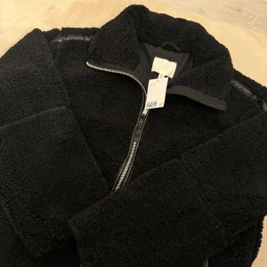 Pilejacka med lös passform  - Säljer en supermysig svart teddyjacka i storlek M. Jackan har en dragkedja framtill och är perfekt för kyliga dagar. passar perfekt till både höst och vinter. Helt ny prislapp kvar 