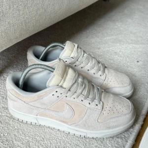 Nike dunk low premium vast grey - Inköp pris 3500kr. ett par snygga och stilrena Nike Dunk i beige mocka. Skorna har en klassisk design med snörning och perforerade detaljer på tån för extra ventilation. Perfekta för både vardag och fest!