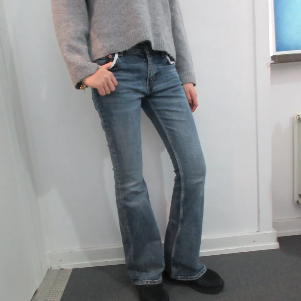 Säljer ett par blåa weekday jeans som är omsydda. De är lowaist men mer som midwaist. De har även både spets och fjärilsdetaljer. W28 och L34. Modellen är 178 cm lång. . Jeans & Byxor.