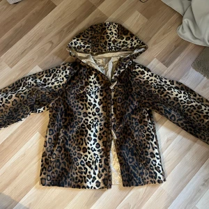 Leopardmönstrad pälsjacka med huva - Säljer en supercool vintage leopardmönstrad pälsjacka med huva. Jackan har långa ärmar och stängs med knappar framtill. Fint skick och väldigt unik 