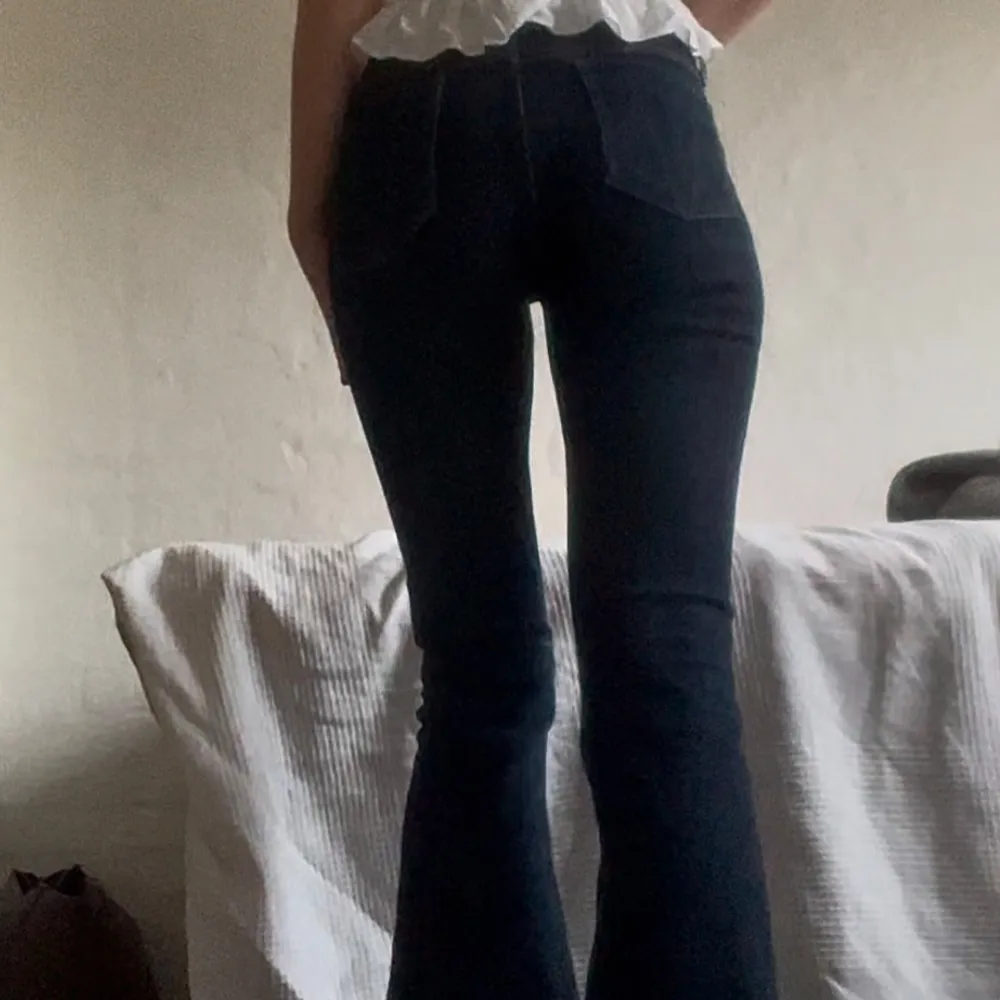 Säljer ett par snygga lågmidjade mörkblå bootcut jeans från Victoria Beckham. I storlek 28, midjemått 39 cm och innerbenslängd 83 cm. Lite slitna längst ner i benen. Första bilden lånad av förra säljaren.. Jeans & Byxor.