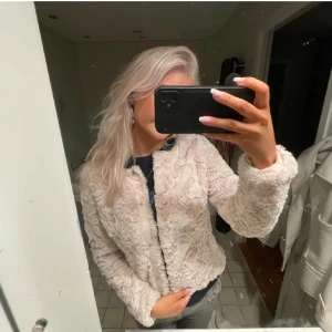 Jacka/kappa - Supermysig beige som är perfekt för alla dagar. Den har en normal passform och långa ärmar. Jackan är gjord av mjukt material. 