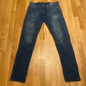 Mörkblåa Replay anbass jeans - Tjena! Jag säljer ett par mörkblå jeans från Replay i bra skick. De har en snygg tvätt och klassisk femficksdesign. Perfekta för både vardag och fest! 🕺(tyvärr har R:et på baksidan ramlat av jag har kvar delarna så jag kan skicka med de i din beställning) Vid minsta fundering skriv till mig