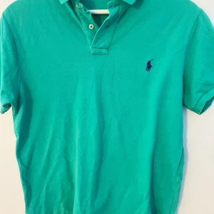 Grön pikétröja från Polo - Säljer en snygg grön pikétröja från Polo i storlek M. Tröjan är i bomull och har en klassisk 