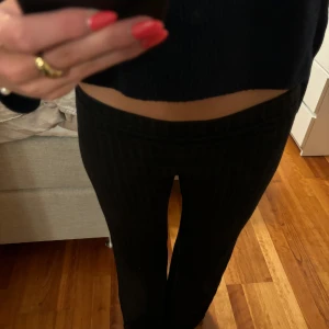 Svarta byxor - Säljer ett par svarta och ribbade byxor i tight passform men vida i benen. Perfekta för både vardag och myskväll. De är låga i midjan och superbekväma. De är använda och har lite nopper på sig men inget som tydligt syns💕💕passar perfekt till vintern.