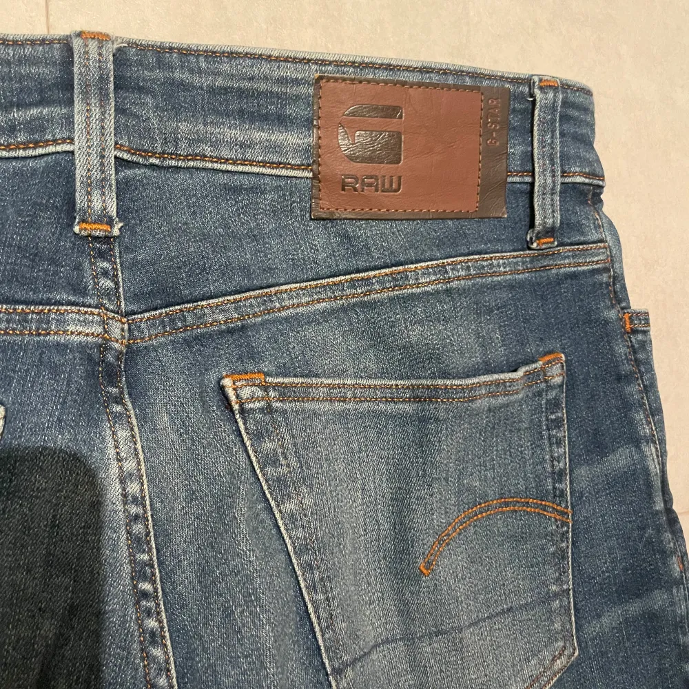 WIDTH: 30 LENGHT: 32 Säljer ett par snygga blå jeans från G-Star RAW. De har en klassisk femficksdesign och en bekväm passform. Jeansen har en lätt tvättad look med subtila slitningar för en trendig stil. . Jeans & Byxor.