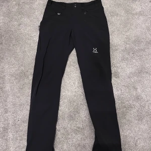 Svarta byxor från Haglöfs - Säljer ett par svarta byxor från Haglöfs i herrstorlek S. Byxorna har en stilren design med dragkedjor och är perfekta för utomhusaktiviteter. De är i mycket bra skick och passar bra för höst- och vårsäsongen.