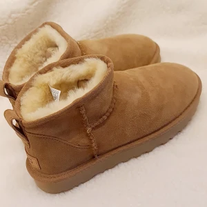 Bruna UGG boots i mocka - Säljer ett par klassiska bruna UGG boots i mocka. De är fodrade med mjuk päls för extra värme och komfort. Perfekta för kalla vinterdagar. Skorna är i nytt skick och kommer i originalförpackning.