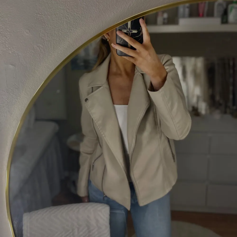 Säljer en snygg beige skinnjacka från Only. Jackan har en cool bikerstil med dragkedja och långa ärmar. Perfekt för höst och vår, och den är i mycket bra skick. Passar perfekt till jeans för en avslappnad look.🧸🦢🪐. Jackor.