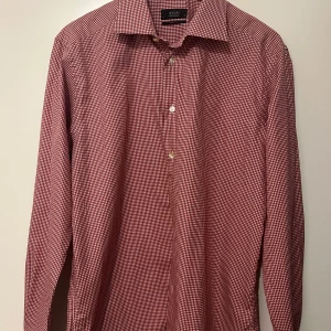 Röd och vit rutig skjorta från Eton - Säljer en snygg röd och vit rutig skjorta från Eton. Skjortan har en klassisk krage och knappar framtill. Perfekt för både vardag och fest! Den är i mycket bra skick och passar perfekt till höst och vår.
