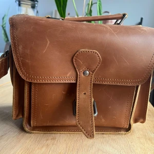 Kameraväska i läder - Helt oanvänd kameraväska i äkta läder. Passar till en systemkamera, med flera fack för tillbehör.