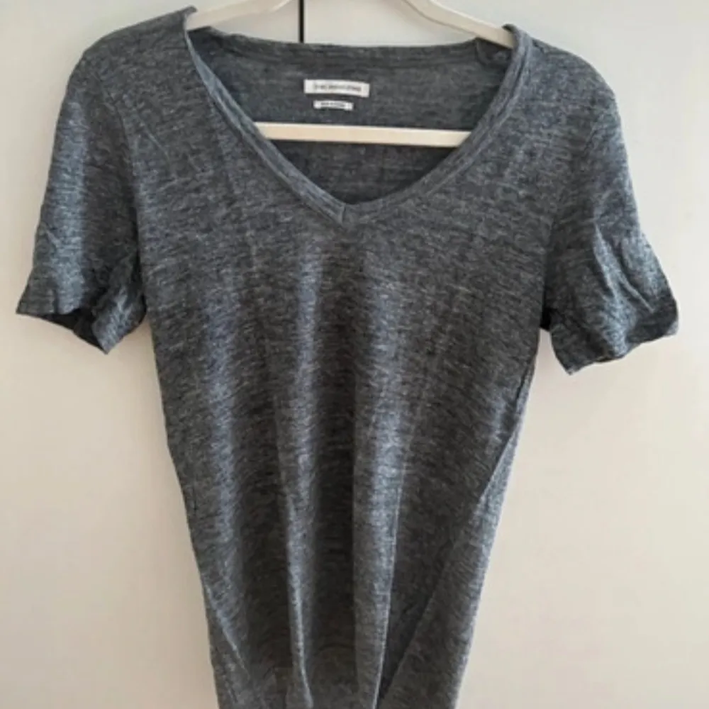 Säljer en snygg grå t-shirt från Isabel Marant Étoile i 100% linne. Den har en v-ringad hals och korta ärmar, perfekt för en avslappnad stil. Toppen är oanvänd och passar både till vardags och festligare tillfällen.. T-shirts.