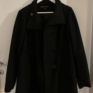 Svart kappa från Ellos - Säljer en elegant svart kappa från Ellos i storlek 40. Den har en klassisk design med knappar framtill och långa ärmar. Perfekt för höst och vinter, och ger en stilren look till vilken outfit som helst. Passar både till vardags och festliga tillfällen.