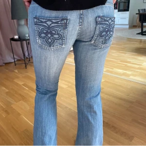 Blå jeans med broderade bakfickor - Säljer ett par snygga blå jeans i bra skick med unika broderade mönster på bakfickorna. De har en bootcut-stil och är perfekta för både vardag och fest. Jeansen är från Polen så dem finns inte att få tag på i Sverige💋🙌i en klassisk blå färg och har en normal passform. 