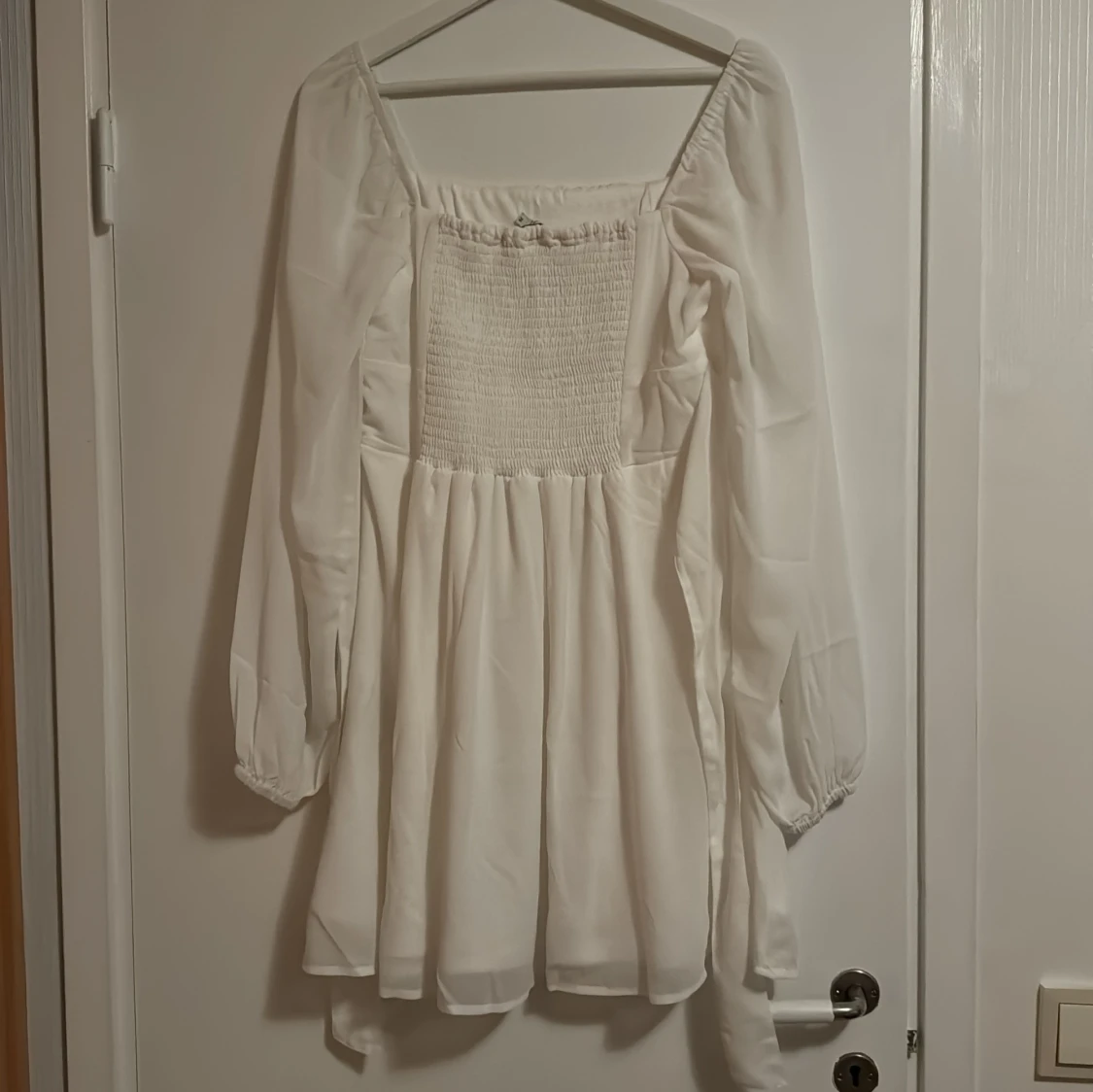 Vit klänning med smockdetalj