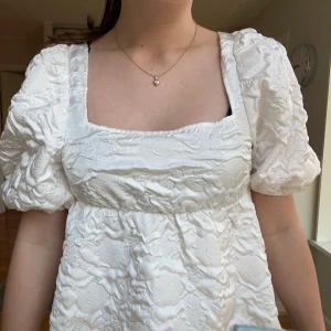 Vit blus med puffärmar - Säljer en superfin vit blus med puffiga kortärmar och öppen rygg. Köpt på H&M i våras och säljer då den andvänds alldeles för lite. Storlek xxs men passar mig som har strl xs/s. Kontakta för fler bilder. 