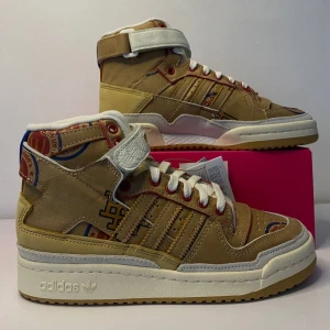 Adidas Forum 84 Hi - Säljer ett par Adidas Forum 84 Hi i beige och brunt med coola McDonald's detaljer. Skorna har en hög modell med snörning och kardborreband för extra stöd. Perfekta för dig som vill sticka ut med en unik stil. Helt nya och oanvända, direkt från boxen!