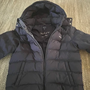 Vinterjacka gant - Säljer en snygg mörkblå dunjacka från GANT i mycket bra skick. Passar 164 cm. 