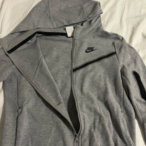 Nike tech kofta - Jag säljer en nike tex kofta, storleken är XL men det är i barn storlek och passar perfekt på mig som har storlek S. Den är knappast andvänd och har inge fläckar eller nått fel på sig, köpte den för 1000 och säljer för 700 men priset kan diskuteras!💕