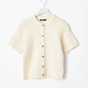 Beige kortärmad kofta  - Säljer en superfin  kofta från Gina tricot med korta ärmar och knappar framtill. Den är mjuk och bekväm, perfekt att ha över en topp. Passar både till vardags och fest. 🧡