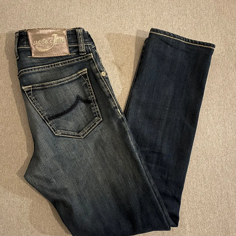 Säljer ett par snygga mörkblå jeans från Jacob Cohen. De har en klassisk femficksdesign och är i mycket bra skick. Perfekta för både vardag och fest! 🕺. Jeans & Byxor.