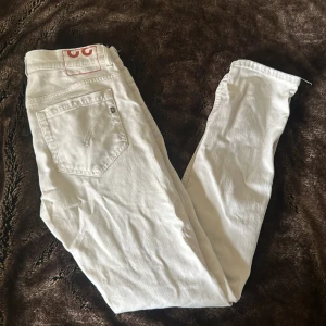 Dondup Jeans - Säljer ett par snygga vita jeans från Dondup i bra skick. De har en klassisk femficksdesign och är tillverkade i Italien. Perfekta för både vardag och fest! Passar till allt och ger en fräsch look. Stl 32 och passar mig som 185
