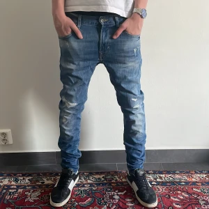 Blå jeans med slitningar - Ett par blå jeans med slitningar | 30W/32L | Fast pris |